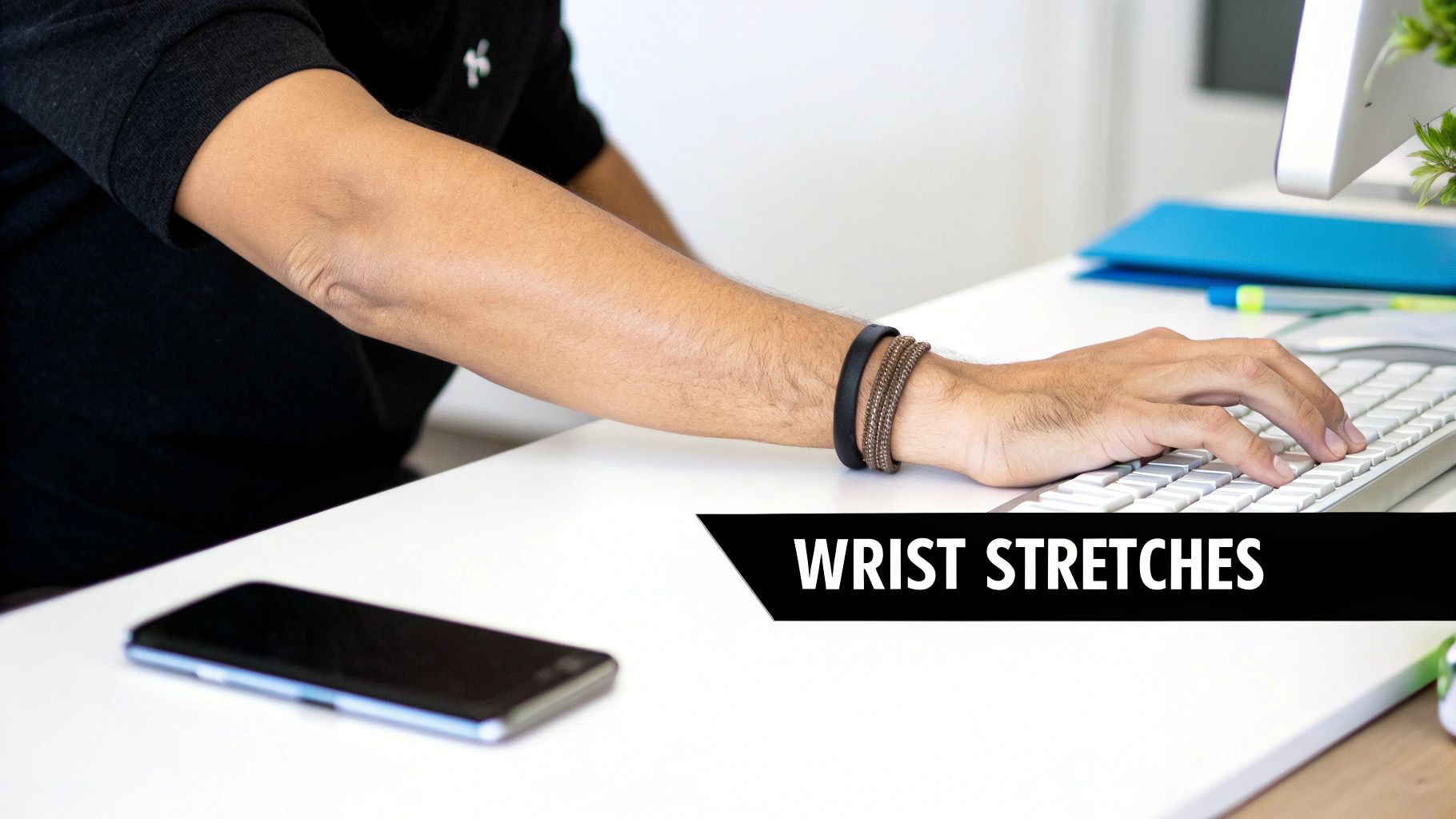 A picture of a man's hand on a keyboard with white text on a black background saying Wrist stretches. 